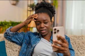 Black British woman reflecting on the emotional impact of social media bullying